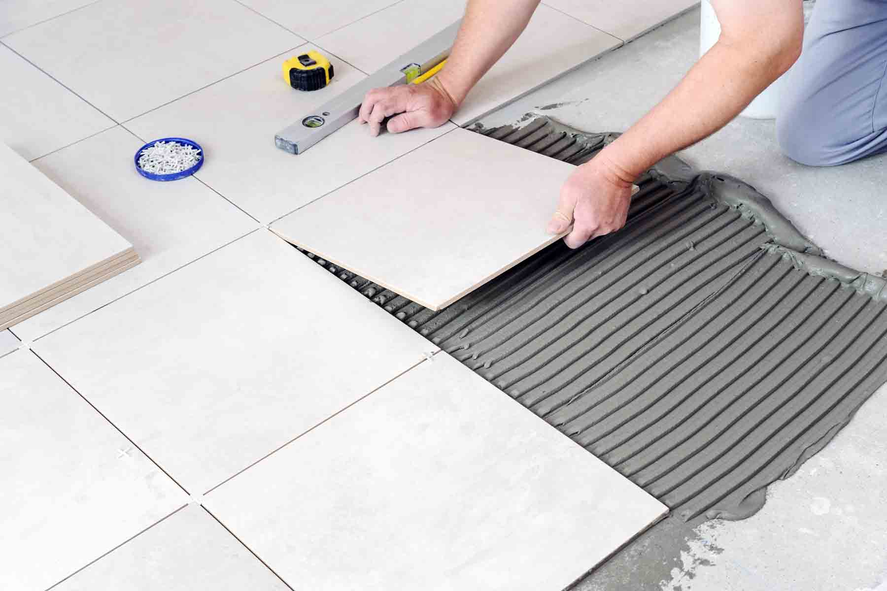 homeguide-worker-installing-ceramic-tile-flooring